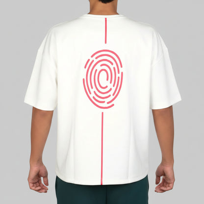 A person shown from the back wearing a white short-sleeve T-shirt with a large pink fingerprint graphic and vertical pink line detail on the back, paired with dark pants against a light gray studio background.